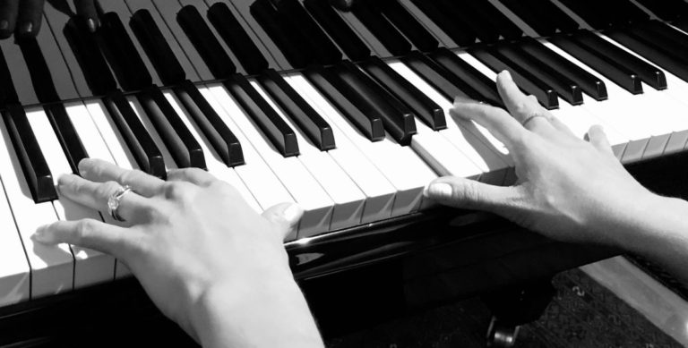 two hands playing the piano